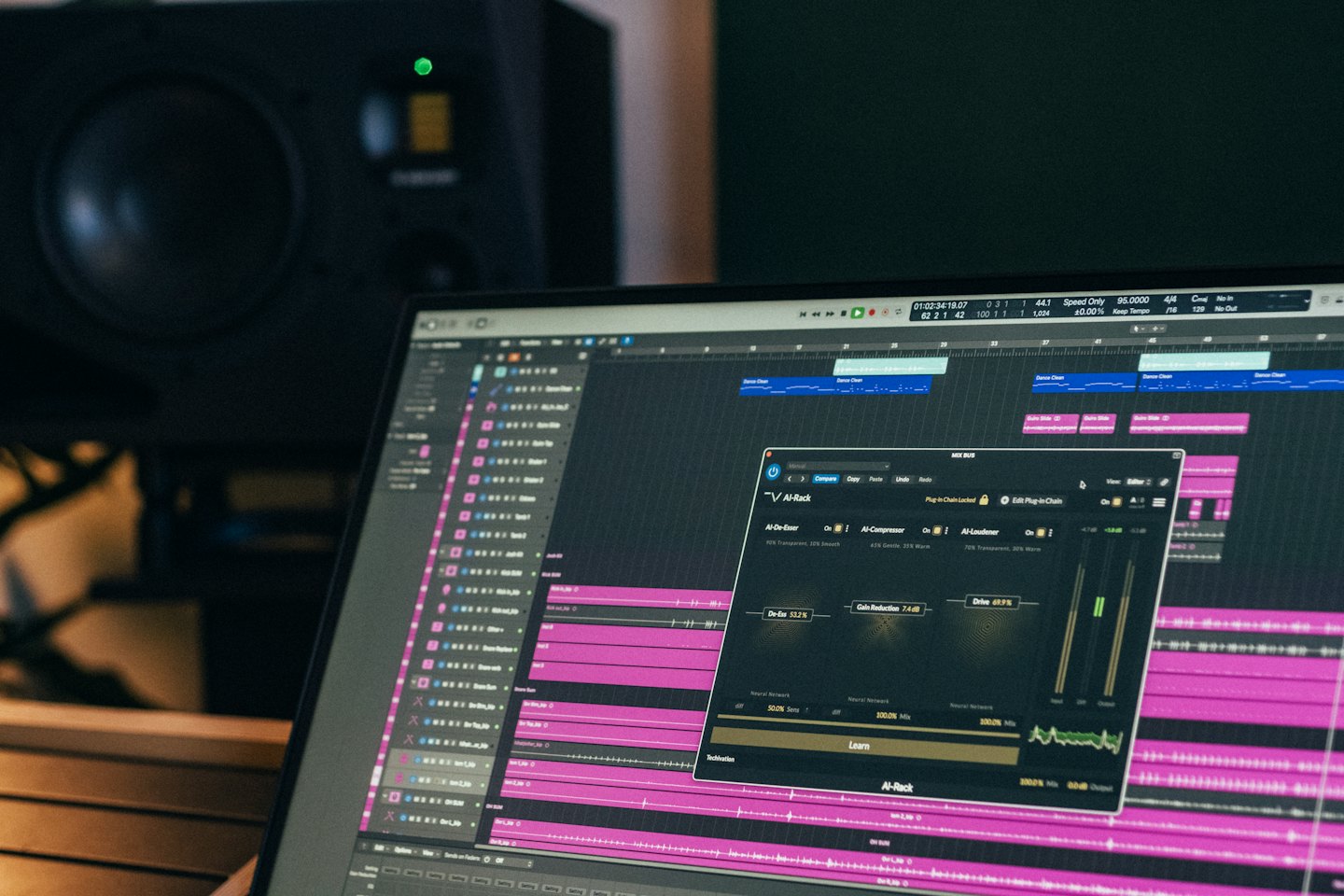 Computer monitor displaying professional music production software with digital waveforms.