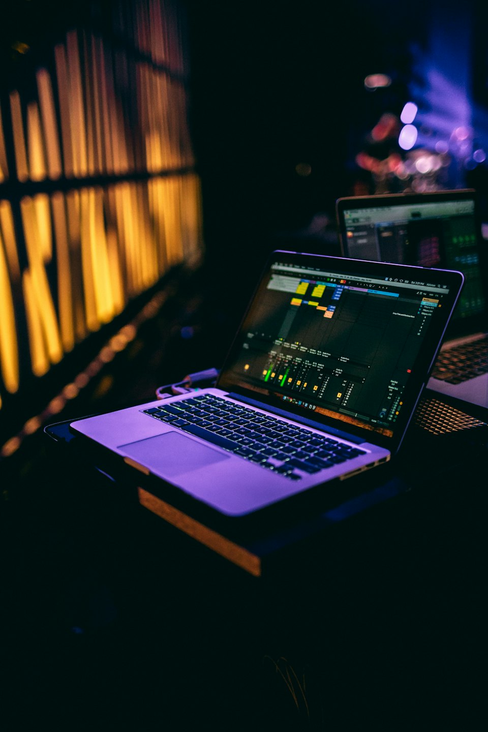 Laptop screen displaying music production software and audio meters.
